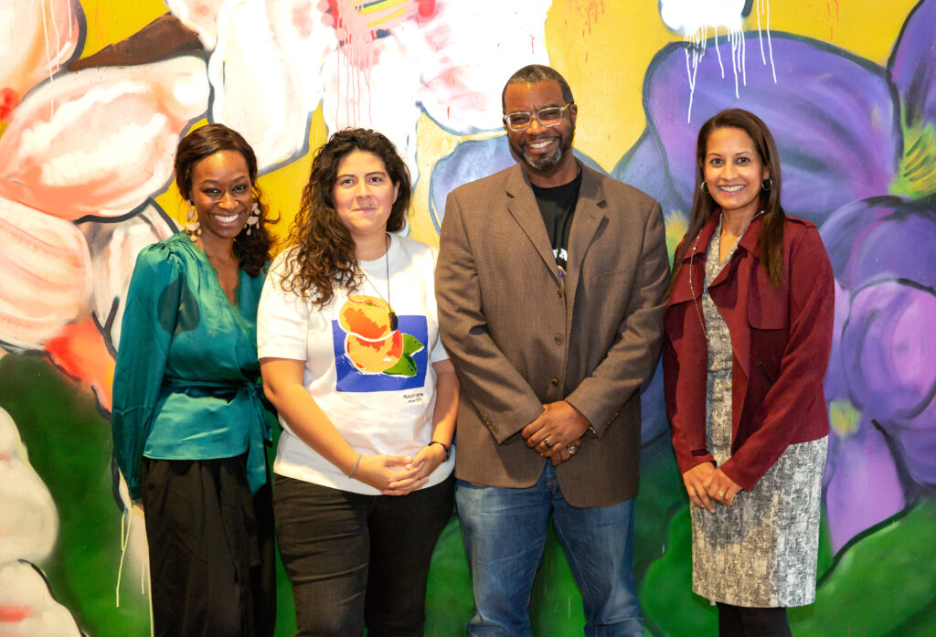 partners in front of a mural