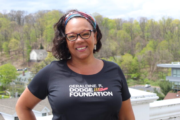 Jennene Tierney, Vice President of People, Culture, and Equity at the Dodge Foundation, stands on an outdoor rooftop garden.